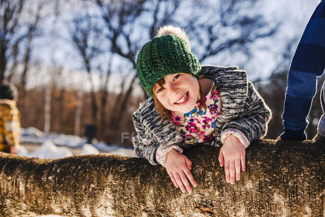 Портрет усміхненої дівчини, що вилазить на дерево (США). — стокове фото