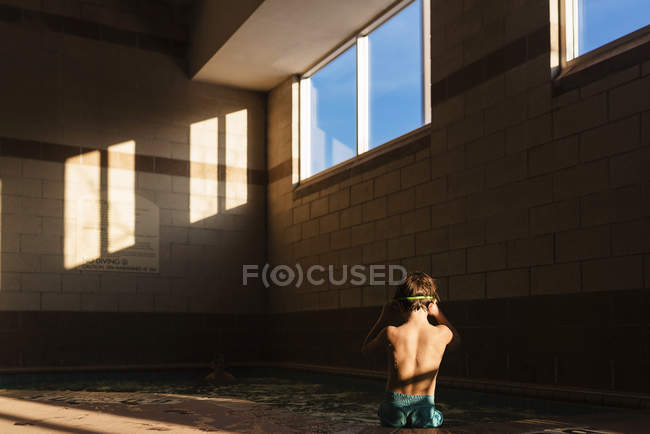 Хлопчик сидить на краю басейну — стокове фото