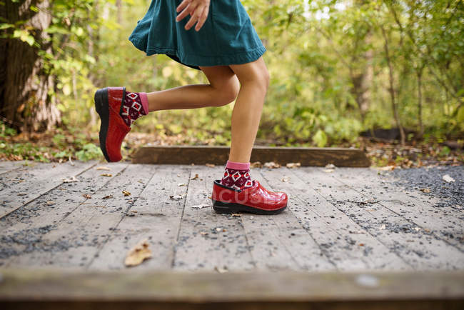 Girl running across a small footbridge, United States — Stock Photo