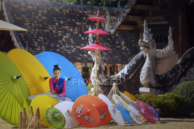 Retrato de una mujer pintando sombrillas tradicionales, Chiang Mai, Tailandia - foto de stock