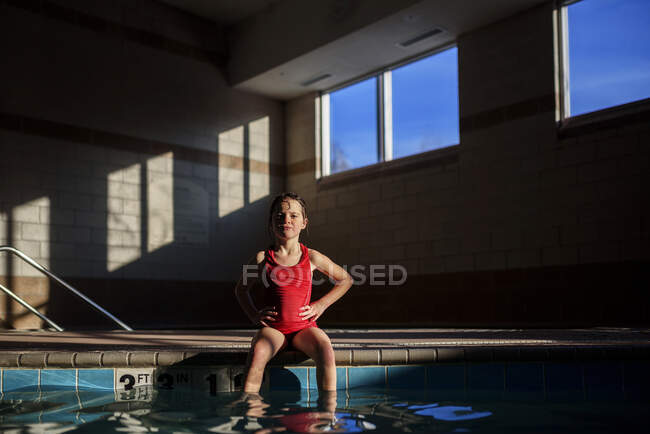 Girl sitting at the edge of a swimming pool — Stock Photo