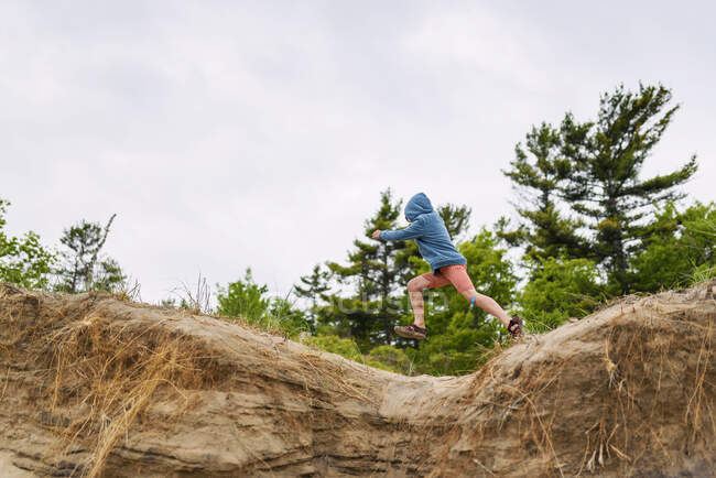 Boy jumping on sand dunes, United States — Stock Photo