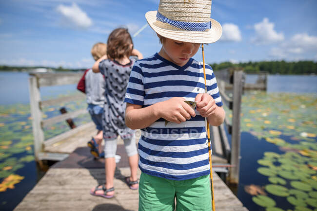Trois enfants pêchent sur un quai en été, États-Unis — Photo de stock