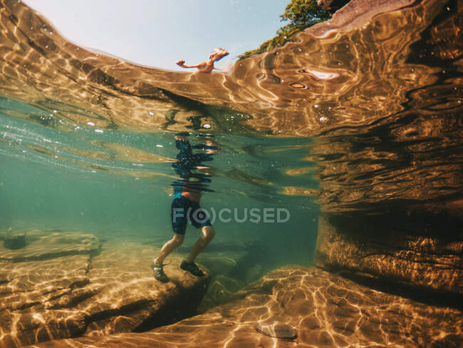 Unterwasserblick eines Jungen, der in einem See geht, Lake Superior, Vereinigte Staaten — Stockfoto
