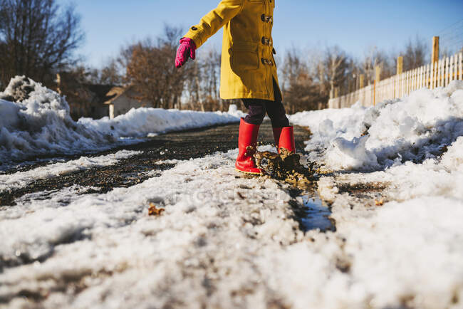 Girl standing in a puddle of melting snow, États-Unis — Photo de stock