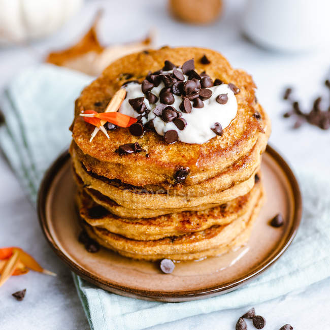 Stack of pumpkin chocolate chip pancakes with yogurt and maple syrup — Stock Photo