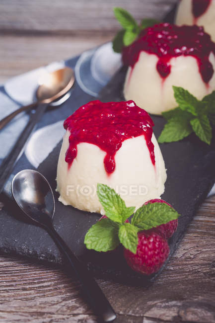 Trois desserts panna cotta avec coulis framboise, framboise et menthe — Photo de stock