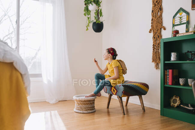 Девушка сидит на стуле и смотрит на листок бумаги. — стоковое фото