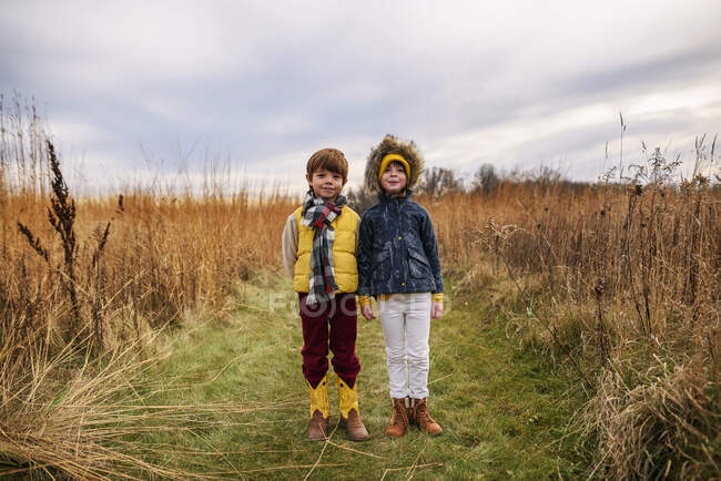 Portrait d'un garçon et d'une fille debout dans un champ, États-Unis — Photo de stock
