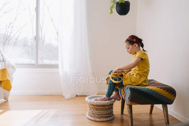 Menina sentada em um banco fechando sua mochila — Fotografia de Stock