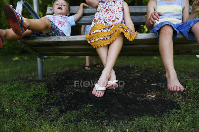 Drei Kinder sitzen auf einer Veranda-Schaukel — Stockfoto