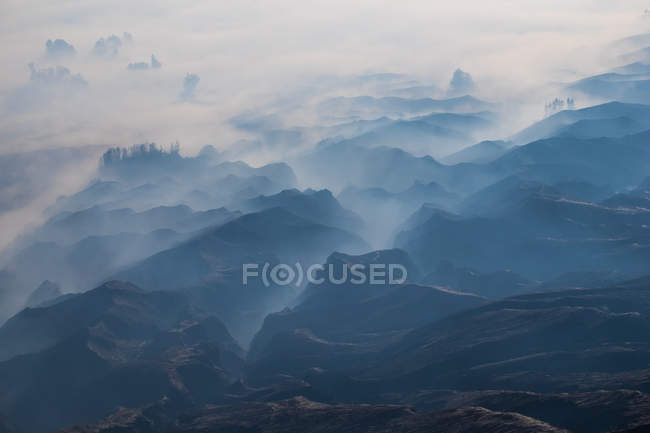 Foggy paysage de montagne au lever du soleil, Bromo Tengger Semeru National Park, Java Est, Indonésie — Photo de stock