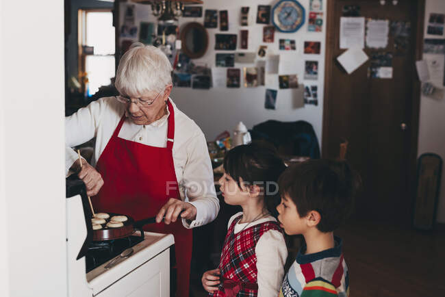 Avó cozinhar tradicionais bolinhos de Natal sueco com seus netos — Fotografia de Stock