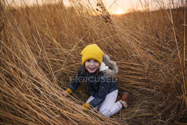Усміхнена дівчина грає на полі на заході сонця (США). — стокове фото