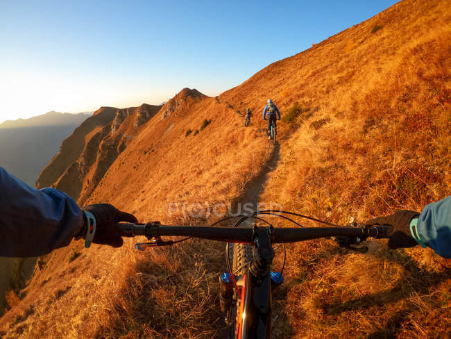 Perspectiva pessoal tiro de um homem de bicicleta de montanha com amigos nos Alpes, Gastein, Salzburgo, Áustria — Fotografia de Stock