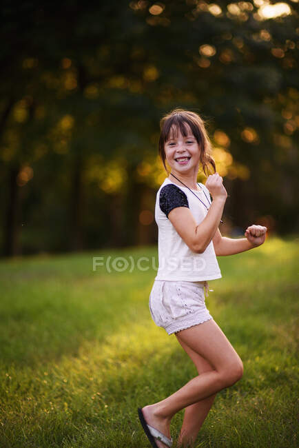 Retrato de uma menina sorridente dançando no parque — Fotografia de Stock