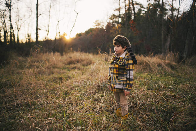 Garçon debout dans les bois en automne, États-Unis — Photo de stock