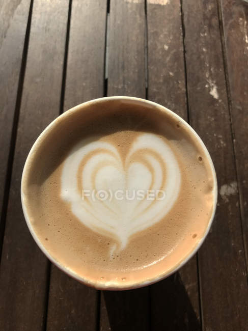 Overhead view of a cappuccino on a wood table — Stock Photo