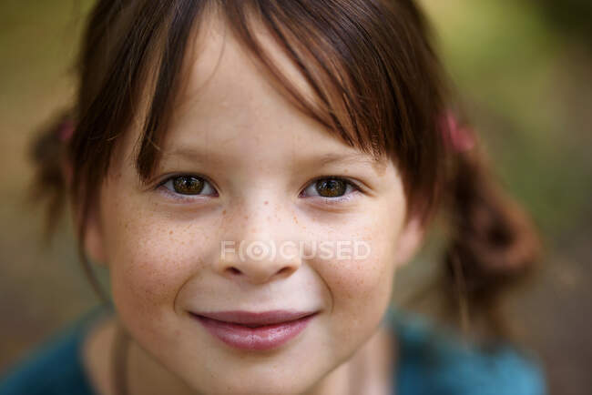 Portrait of a smiling girl with freckles standing outdoors, United States — Stock Photo
