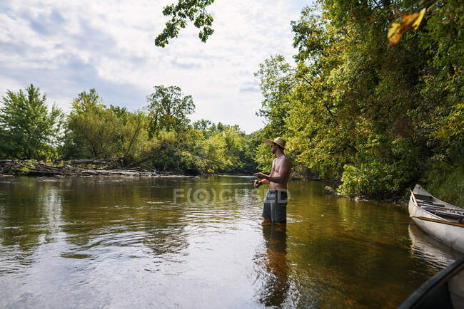 Homme debout dans une rivière de pêche, États-Unis — Photo de stock