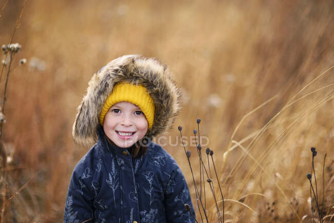 Retrato de una chica sonriente de pie en un campo, Estados Unidos - foto de stock
