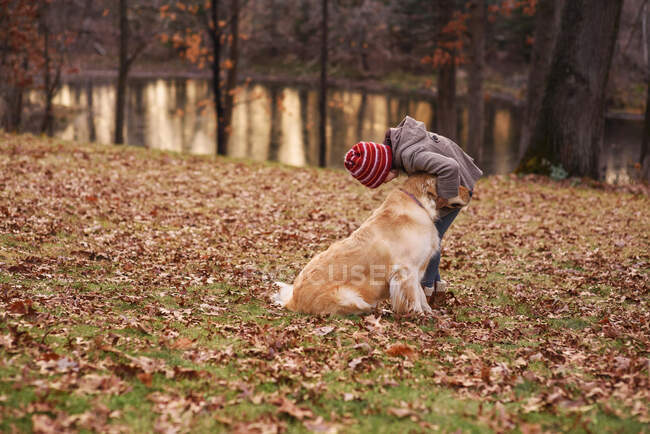 Девушка, стоящая в лесу и играющая со своей собакой, США — стоковое фото