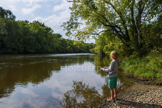 Хлопець, що стоїть на березі річки (США). — стокове фото