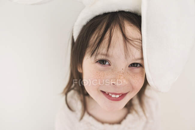 Portrait d'une fille souriante portant des oreilles de lapin — Photo de stock