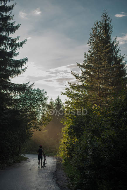 Rear view of a Cyclist in lycra walking down a road, Bosnia and Herzegovina — Stock Photo