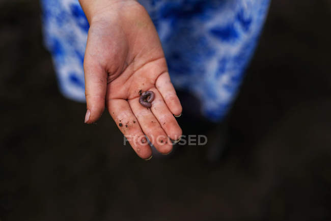 Menina segurando um verme na mão — Fotografia de Stock
