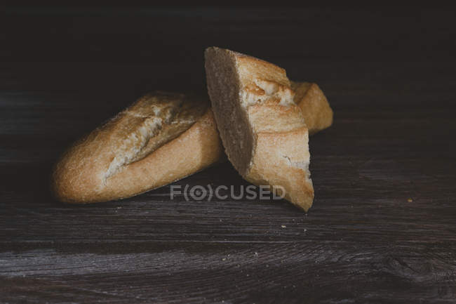 Slices of French bread on a wooden table — Stock Photo