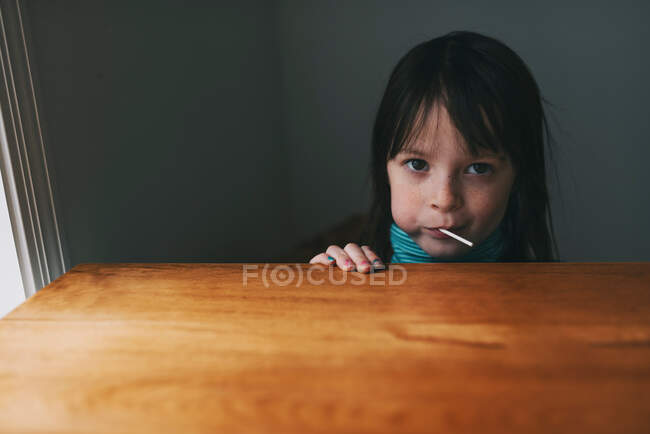 Retrato de una chica comiendo una piruleta - foto de stock