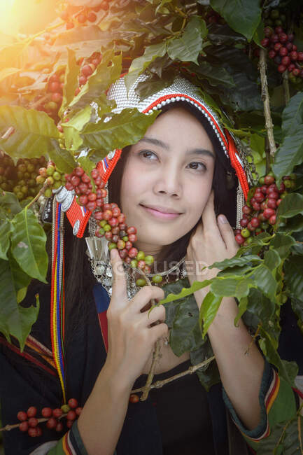 Ritratto di una donna sorridente accanto a piante di caffè, Thailandia — Foto stock