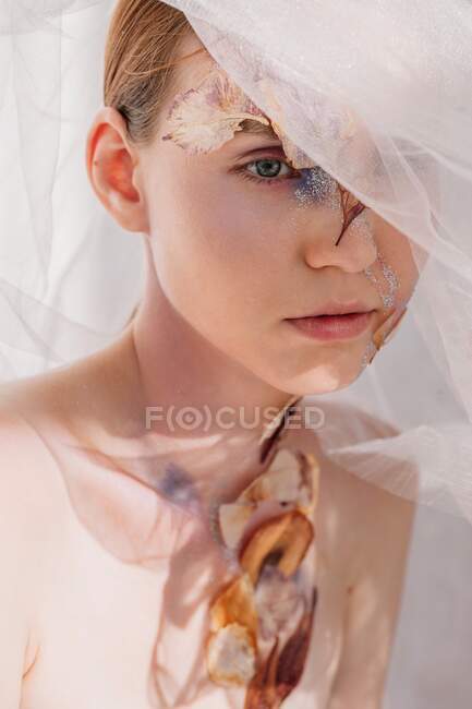 Ritratto concettuale di bellezza di una donna che indossa un velo con fiori secchi sul viso e sul collo — Foto stock