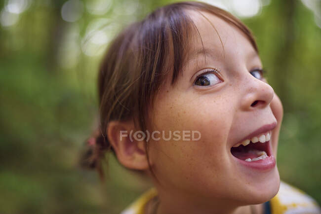 Porträt eines lächelnden Mädchens, das im Freien steht und lustige Gesichter zieht, Vereinigte Staaten — Stockfoto