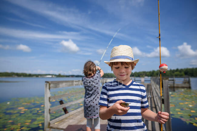 Dos niños que pescan en un muelle en el verano, Estados Unidos - foto de stock