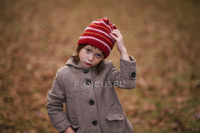 Retrato de una niña de pie en el bosque con la mano sobre la cabeza, Estados Unidos - foto de stock