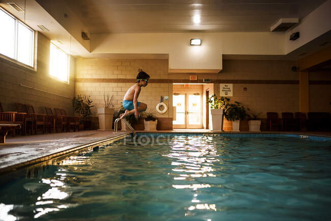 Хлопчик стрибає в басейн — стокове фото