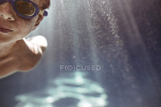 Primo piano di un ragazzo che nuota sott'acqua in una piscina — Foto stock