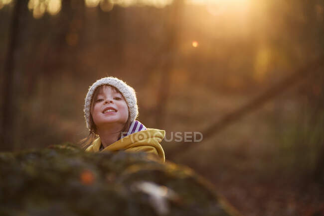 Retrato de uma menina sorridente na floresta ao pôr-do-sol, Estados Unidos — Fotografia de Stock