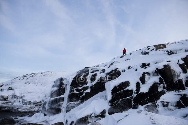 Man standing on cliff by Barents Sea in winter, Murmansk, Rússia — Fotografia de Stock