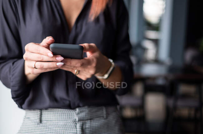 Primer plano de una mujer de negocios usando un teléfono móvil - foto de stock