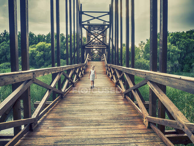 Ragazza che cammina attraverso un ponte di legno, Ungheria — Foto stock