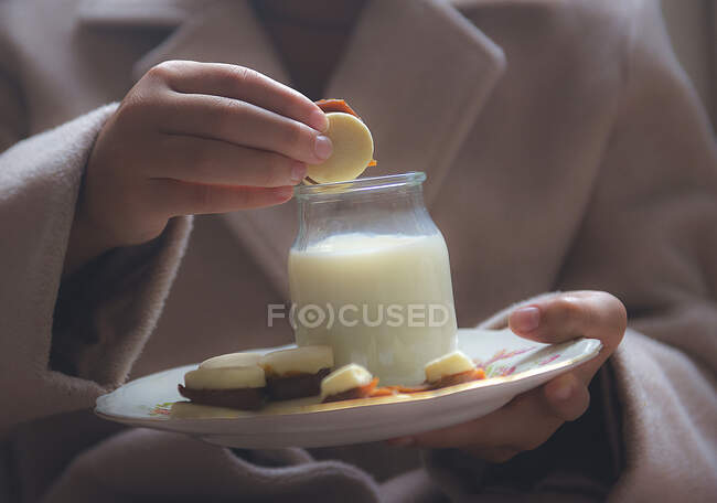 Girl enjoying dulce de leche cookies and milk — Stock Photo