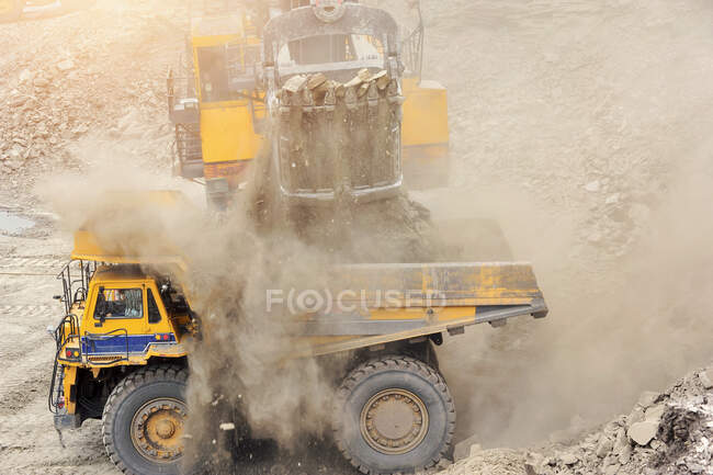 Mineração Caminhão, mineração a céu aberto de minério de ferro e magnetita ores.Loading o minério de ferro em caminhão de descarga pesada na mineração a céu aberto. — Fotografia de Stock