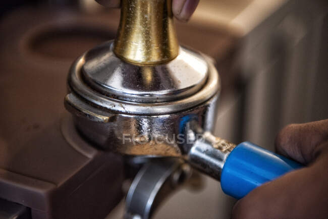 Close-up of a person attaching a portafilter to an espresso machine in a cafe — Stock Photo