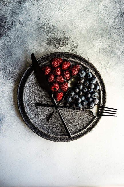 Свежие ягоды с малиной и черникой на темном фоне — стоковое фото