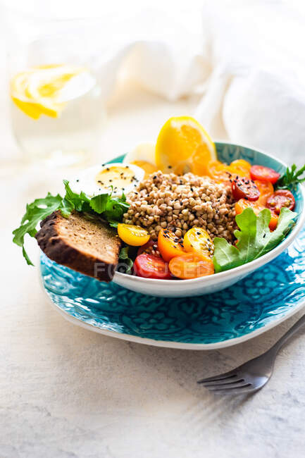 Gesunde Frühstücksschale mit Quinoa, Huhn, Gemüse und Gewürzen auf dem Hintergrund eines Tisches. Ansicht von oben — Stockfoto