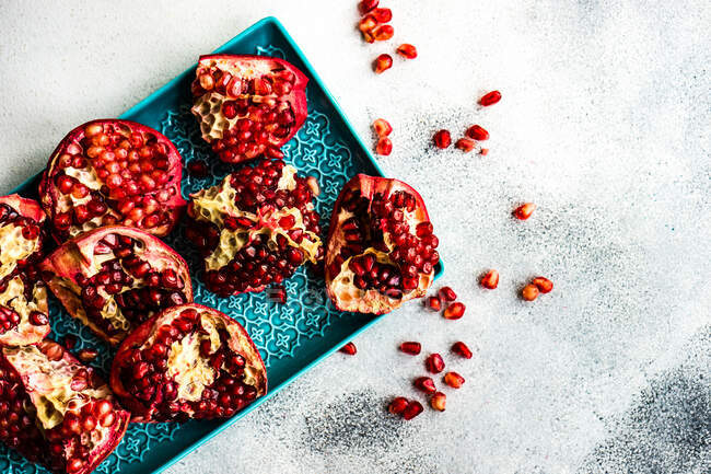 Fresh ripe pomegranate seeds on a blue background. top view. — Stock Photo