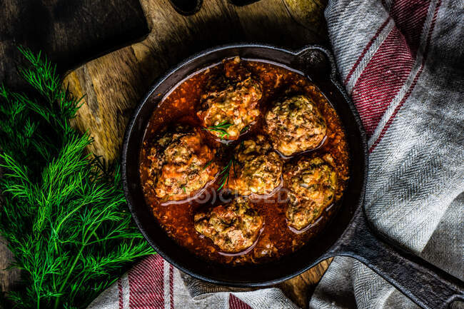 Baked potato with meat and spices in a cast iron skillet. selective focus. — Stock Photo
